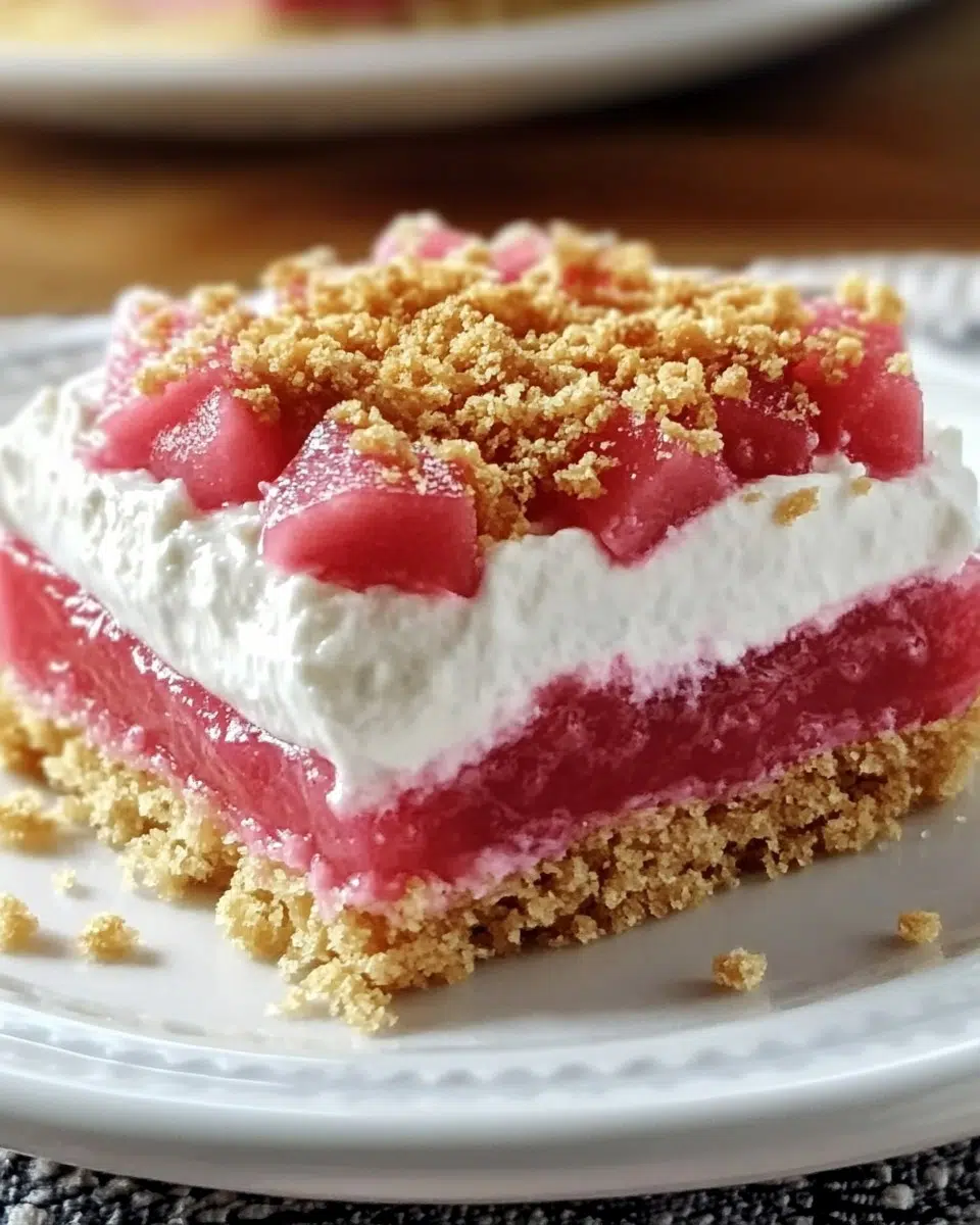 Vibrant no-bake rhubarb dessert with creamy layers and a tangy sweet topping.