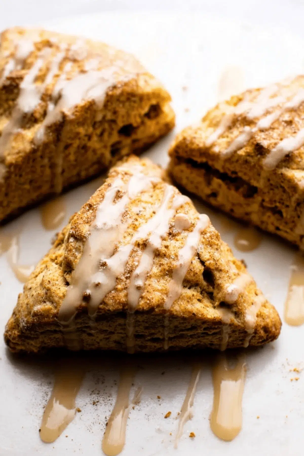 Warm pumpkin scones with a sweet white glaze, perfect for fall.