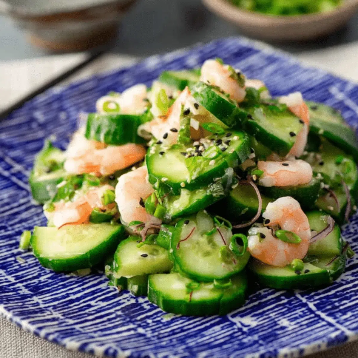 Refreshing Japanese Sunomono salad with thinly sliced cucumbers and cooked shrimp.