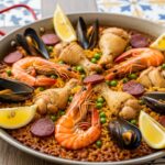 A vibrant and authentic Spanish Paella dish overflowing with saffron rice, shrimp, mussels, chicken, and fresh vegetables, ready to be served.