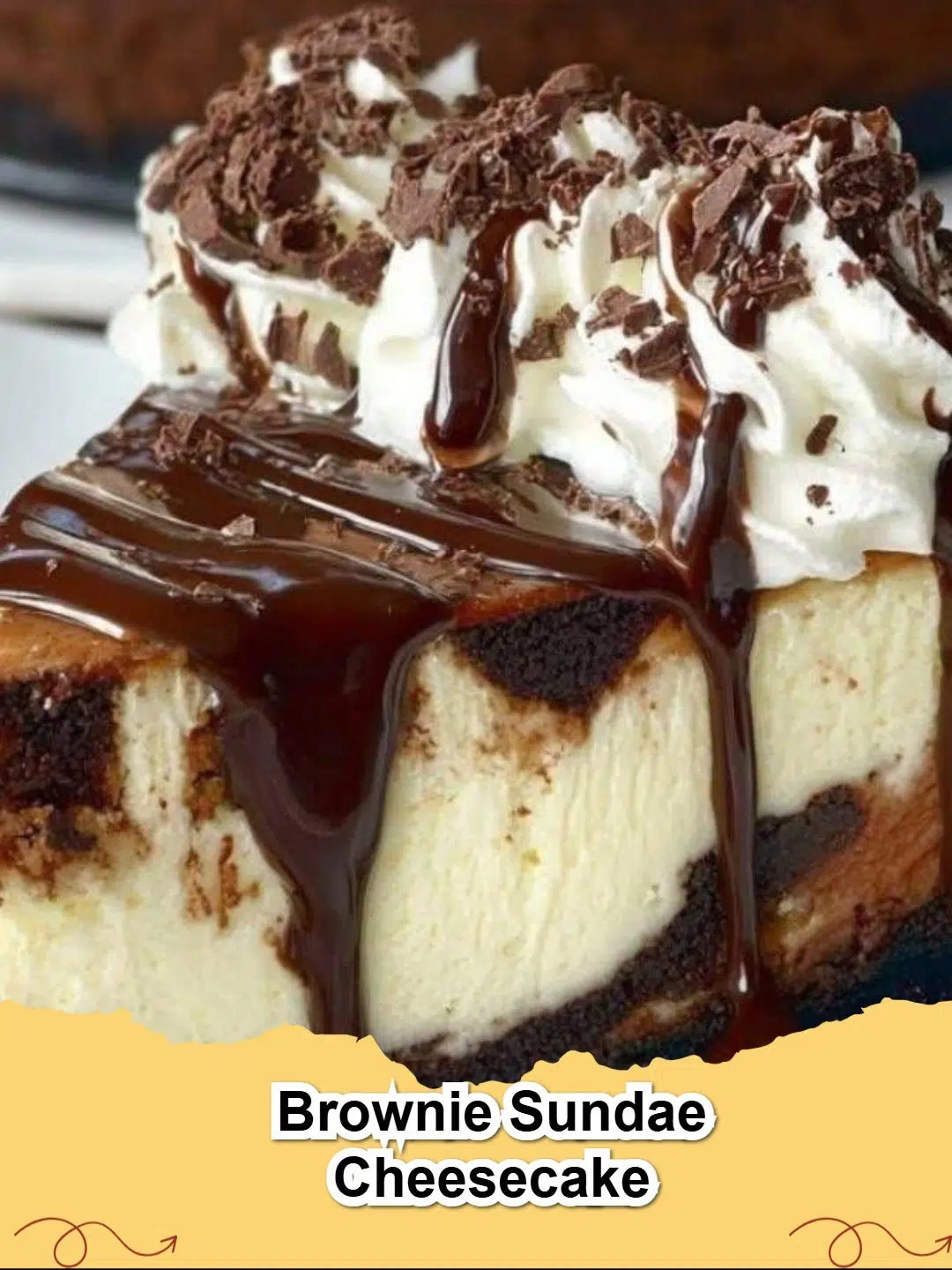 A slice of rich Brownie Sundae Cheesecake, layered with chocolate crust, fudgy brownie, creamy cheesecake, and topped with hot fudge, whipped cream, sprinkles, and a cherry.