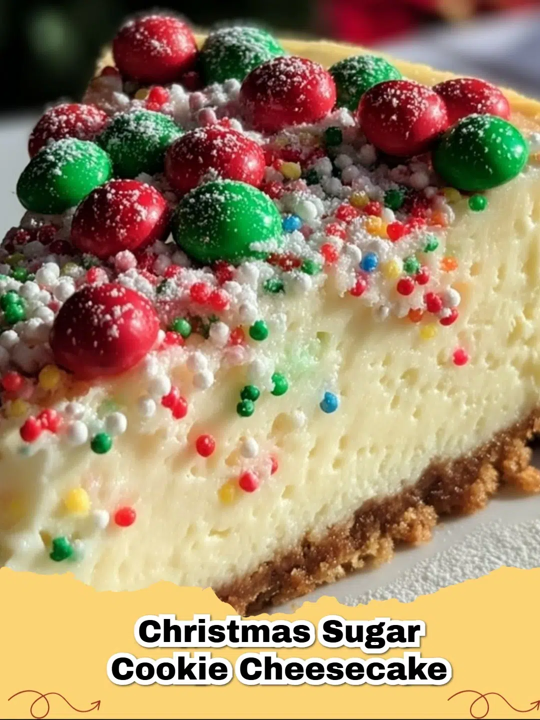A festive Christmas Sugar Cookie Cheesecake decorated with red and green candies, sitting on a holiday table.