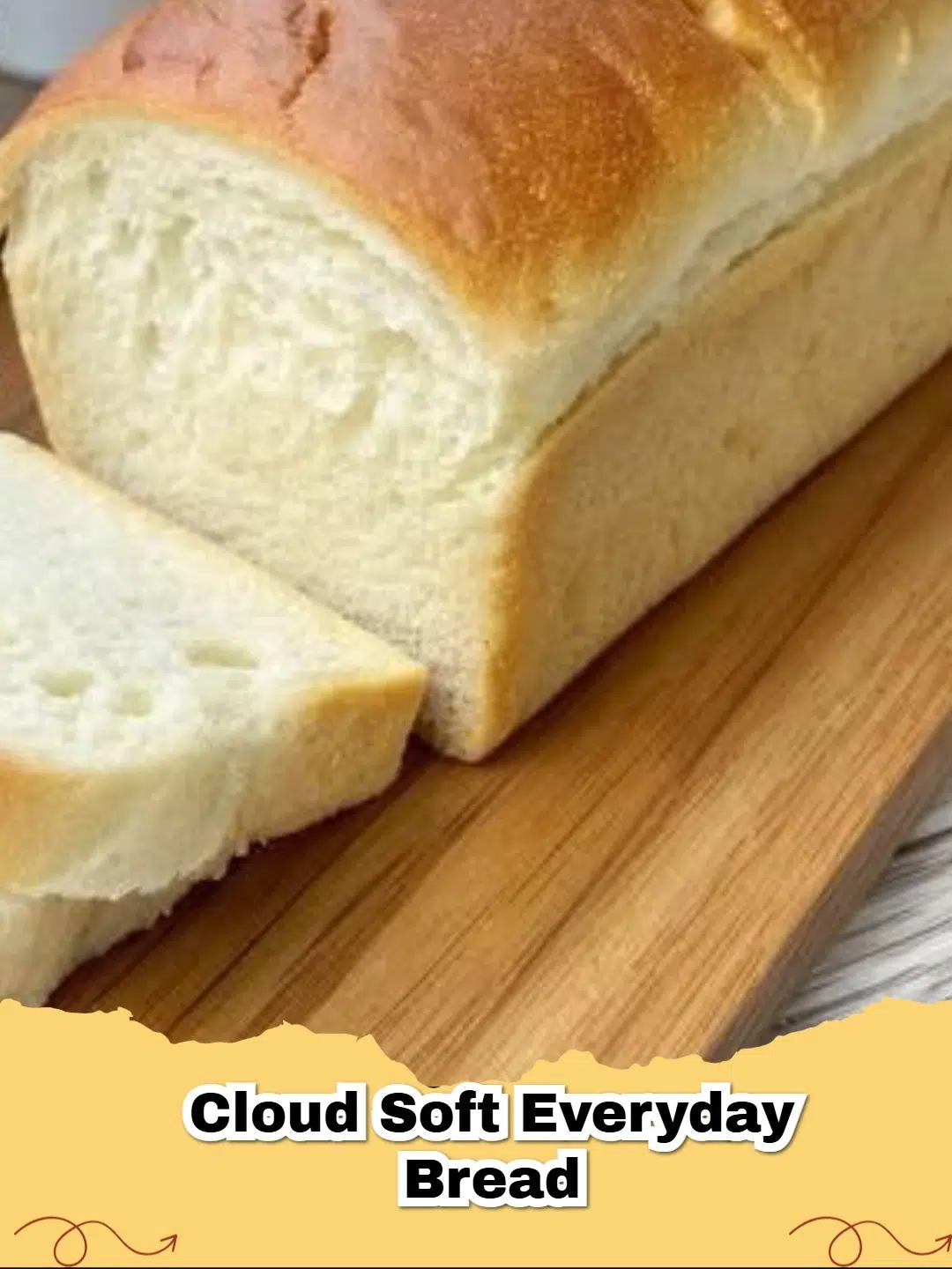 A perfectly baked loaf of Cloud Soft Everyday Bread with a golden crust, sliced on a cutting board, ready to be enjoyed.