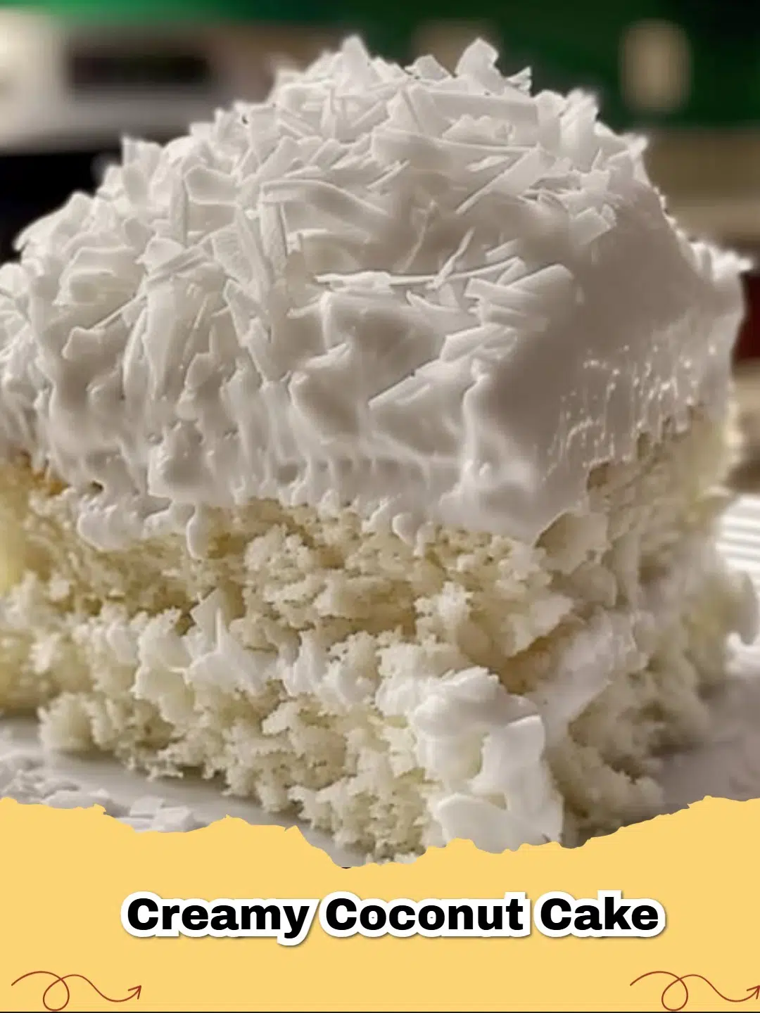 Slice of moist Creamy Coconut Cake topped with whipped cream and toasted flaked coconut.