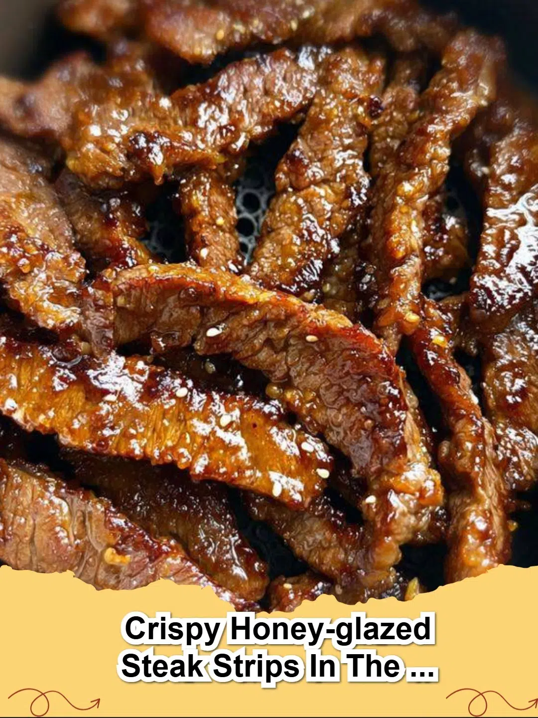 Crispy Honey-Glazed Air Fryer Steak Strips garnished with sesame seeds and fresh green onions