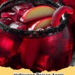 Spooky Halloween Poison Apple Punch in a glass with dry ice fog and apple slices, perfect for a party.