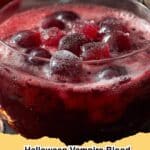 Vibrant red Halloween Vampire Blood Punch in a punch bowl with spooky garnishes