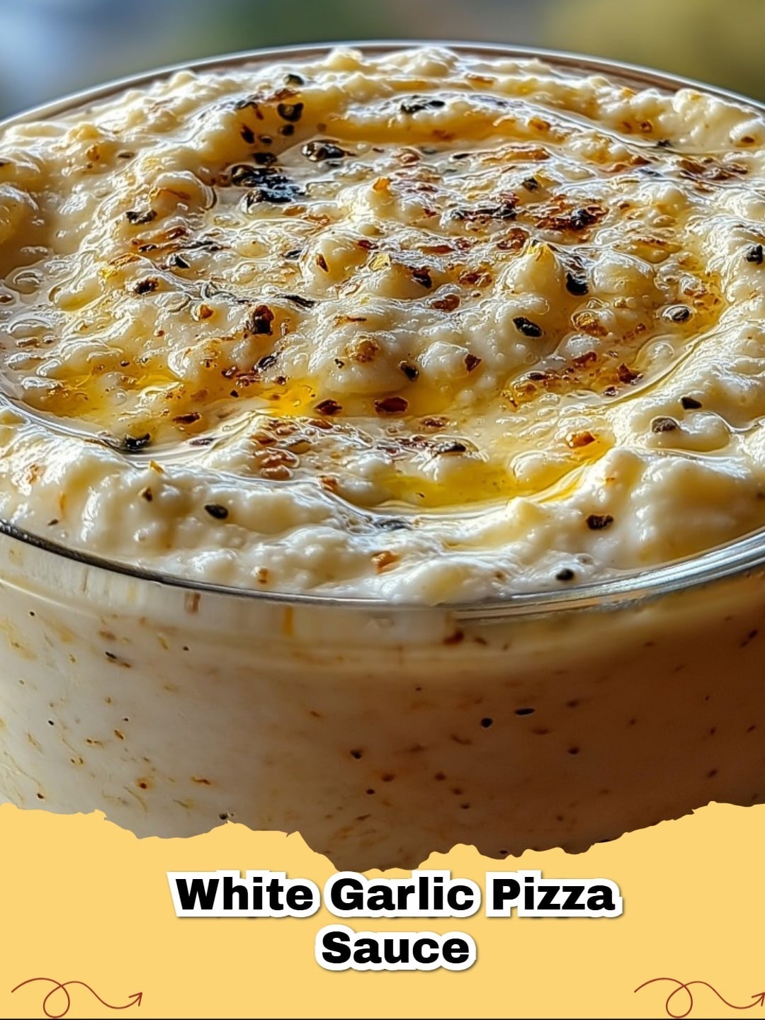 Creamy White Garlic Pizza Sauce in a bowl on a wooden board, ready for pizza making.