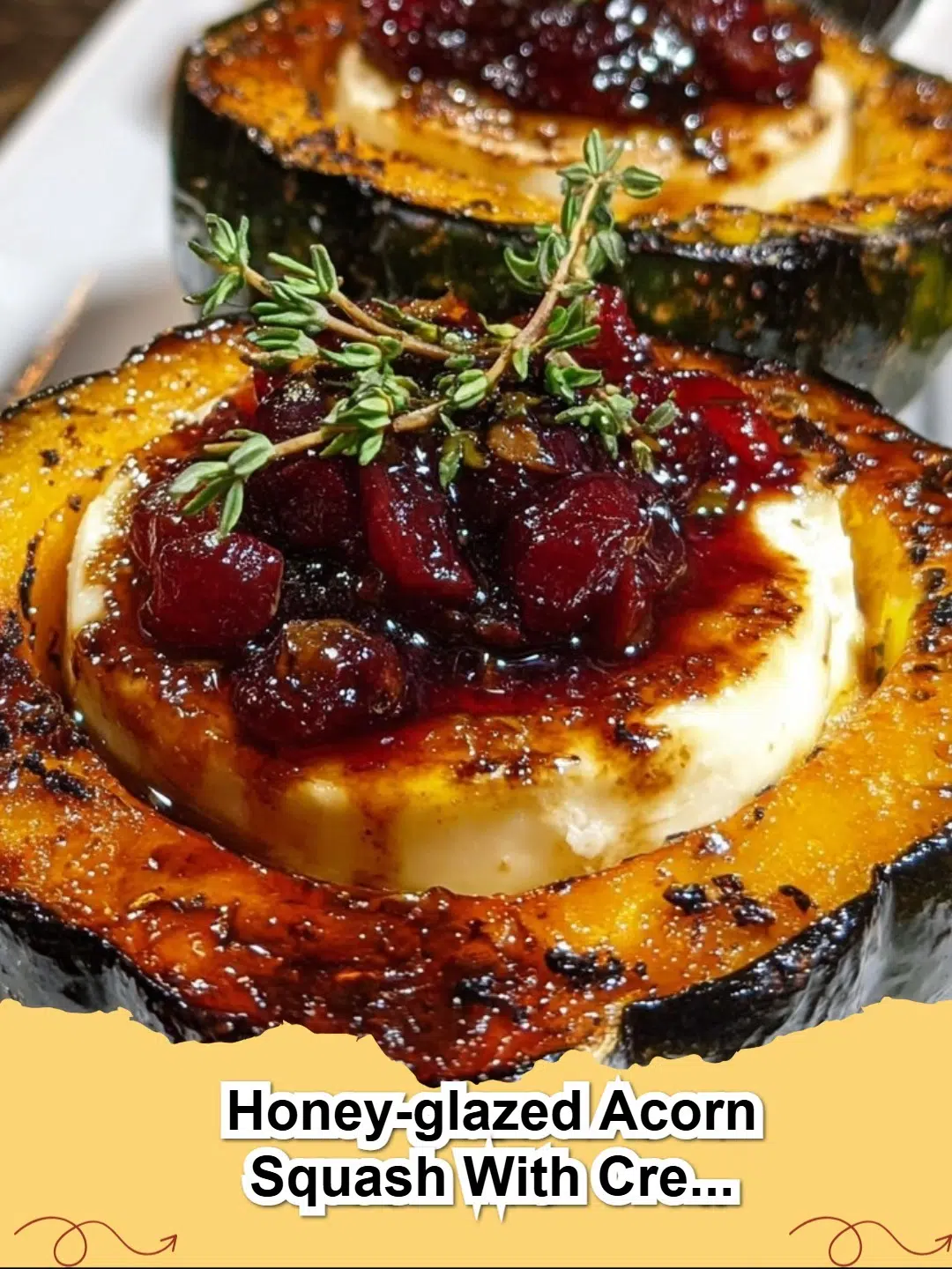 Two halves of Honey-Glazed Acorn Squash, filled with creamy goat cheese and drizzled with cranberries, on a white plate.