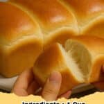 A golden brown loaf of Japanese Milk Bread with a soft, fluffy texture on a wooden board.