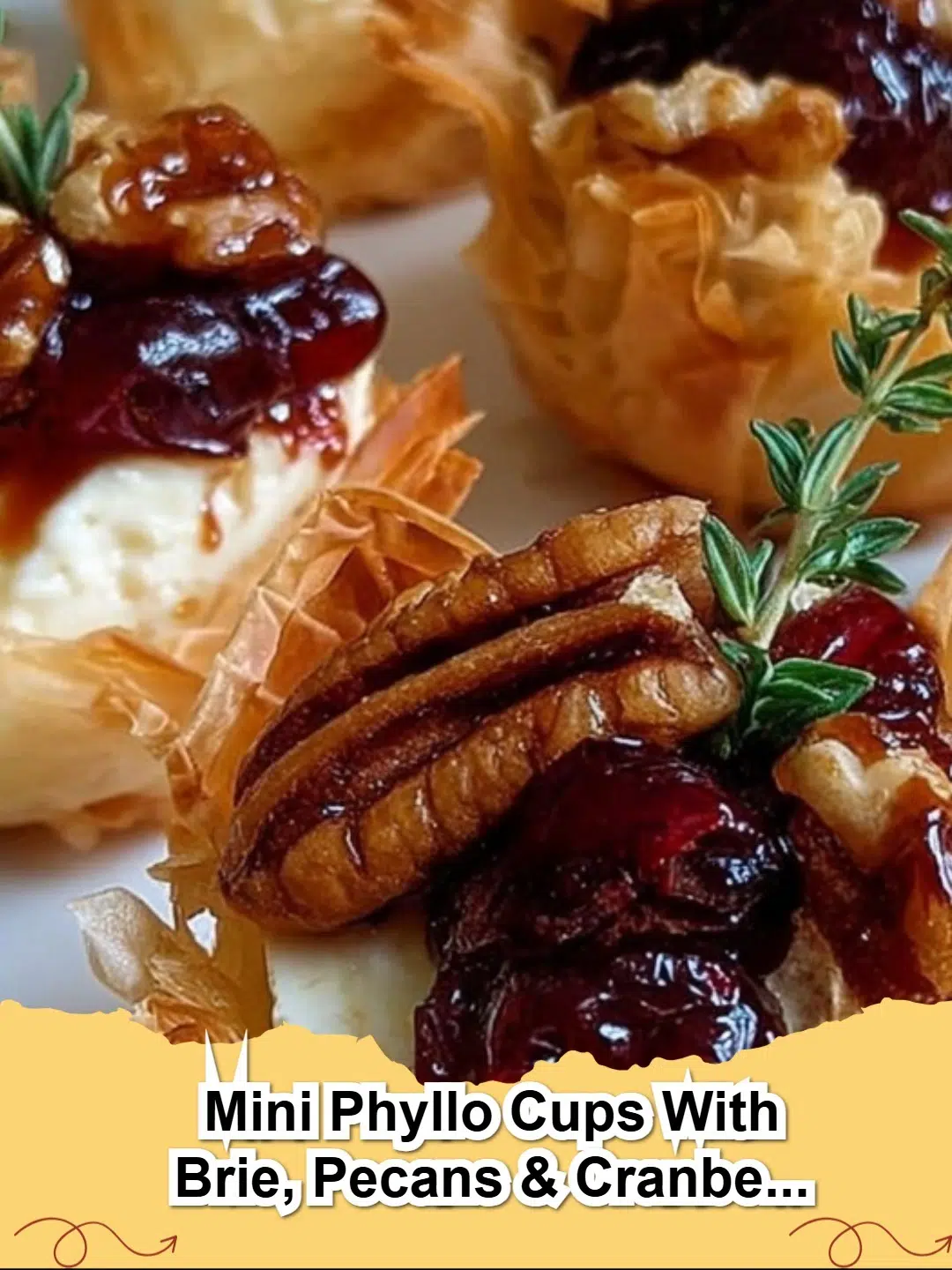 Close-up of baked Mini Phyllo Cups filled with melted brie, toasted pecans, and a glistening cranberry honey drizzle, ready to serve.