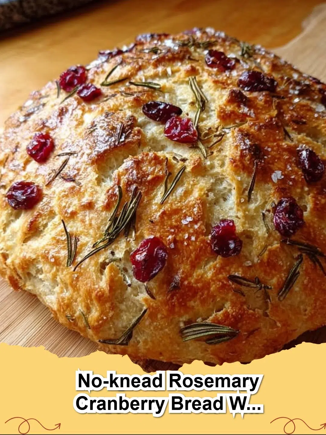 Rustic No-Knead Rosemary Cranberry Bread loaf with olive oil and sea salt, sliced, revealing soft interior.