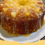 Delicious golden Pineapple Pound Cake loaf drizzled with a sweet pineapple glaze, served on a white plate