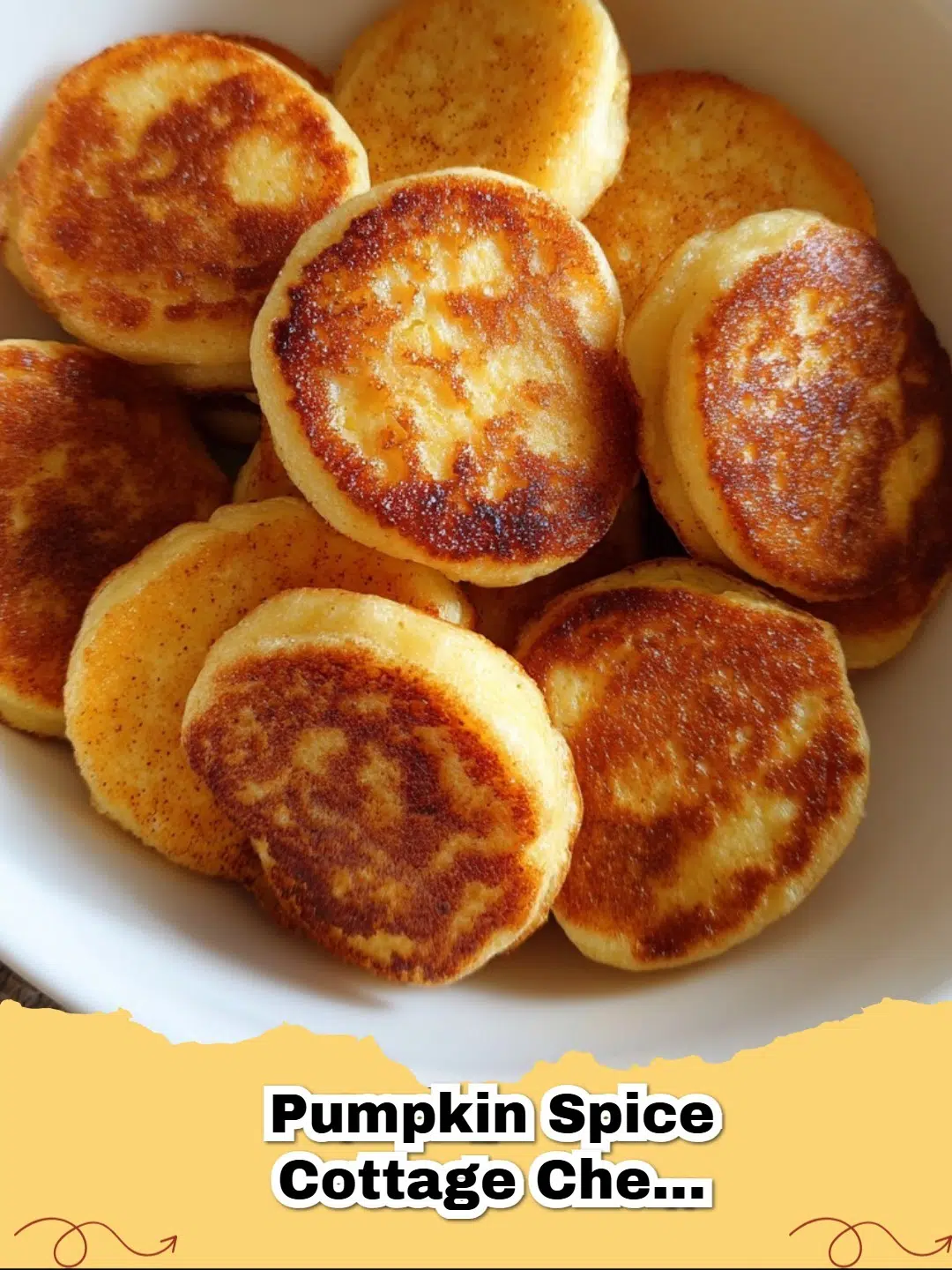 A close-up of golden brown Pumpkin Spice Cottage Cheese Pancake Bites, lightly dusted with powdered sugar, arranged on a rustic wooden board.