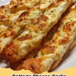 Crispy, golden brown 3-Ingredient Cottage Cheese Garlic Breadsticks on a baking sheet, ready to serve as a high-protein snack.
