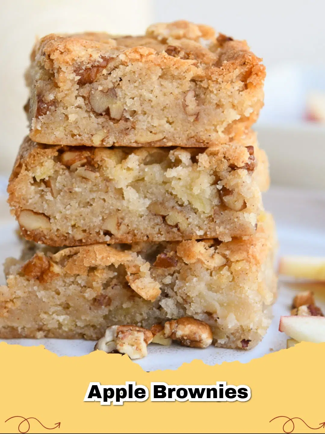 Delicious homemade apple pecan brownies with a dusting of powdered sugar on a wooden board.