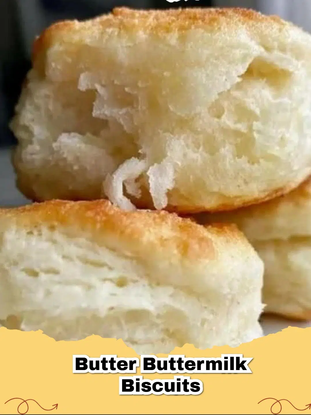 Pile of golden-brown, flaky buttery buttermilk biscuits on a cooling rack.