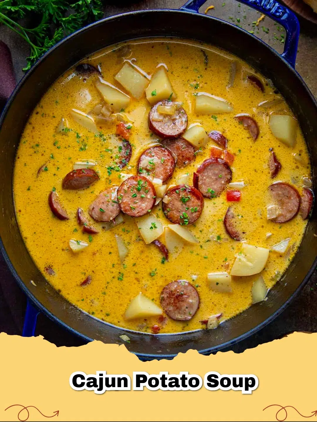 A steaming bowl of creamy Cajun Potato Soup with slices of Andouille sausage and fresh green garnish.