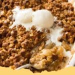Delicious golden brown classic apple crumble with a scoop of vanilla ice cream