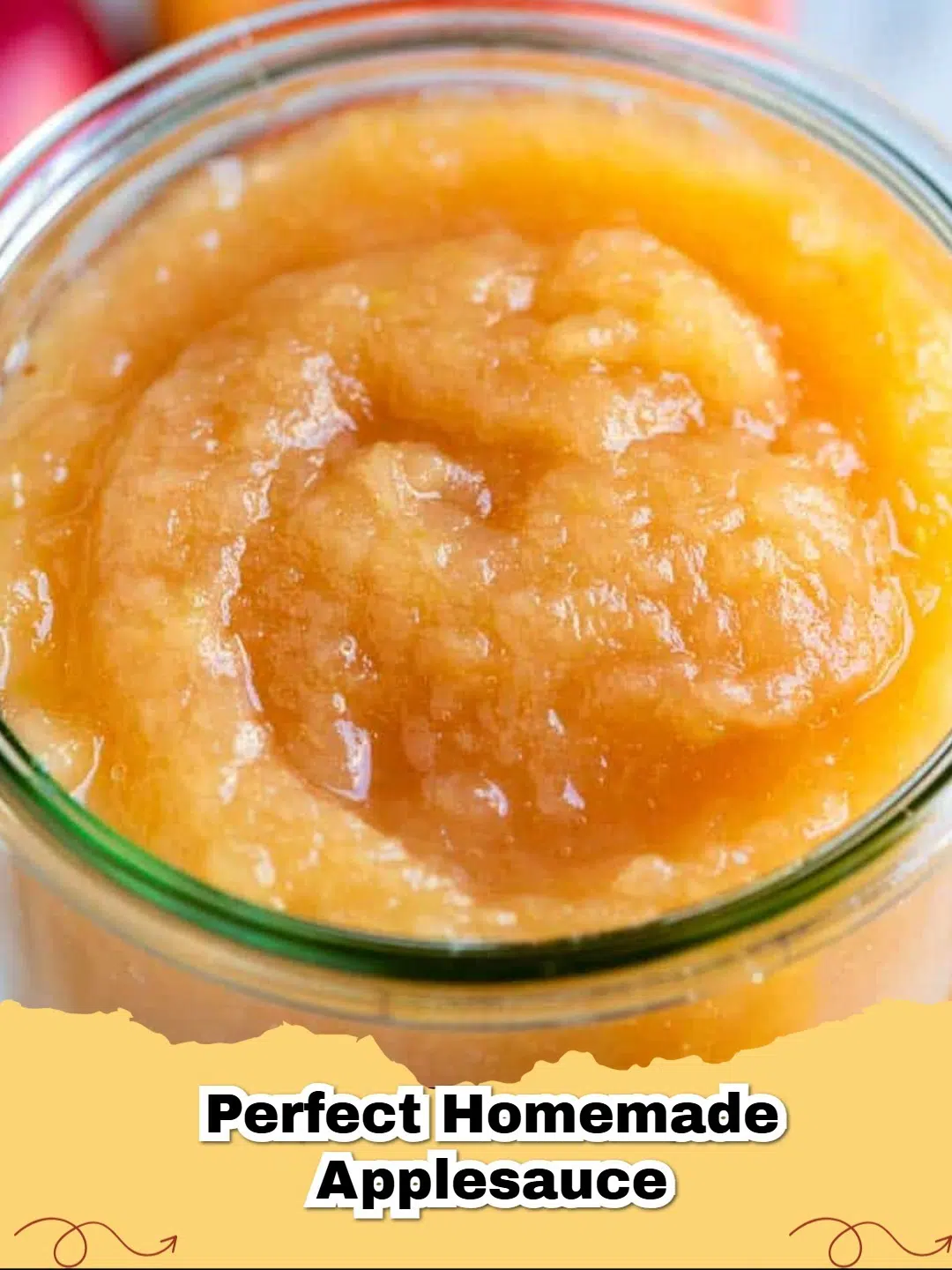 Freshly made homemade applesauce in a white bowl with a cinnamon stick and fresh apples on a wooden surface