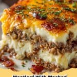 Classic Meatloaf with Mashed Potatoes and Cheese, topped with melted cheddar, served on a white plate with green garnish.