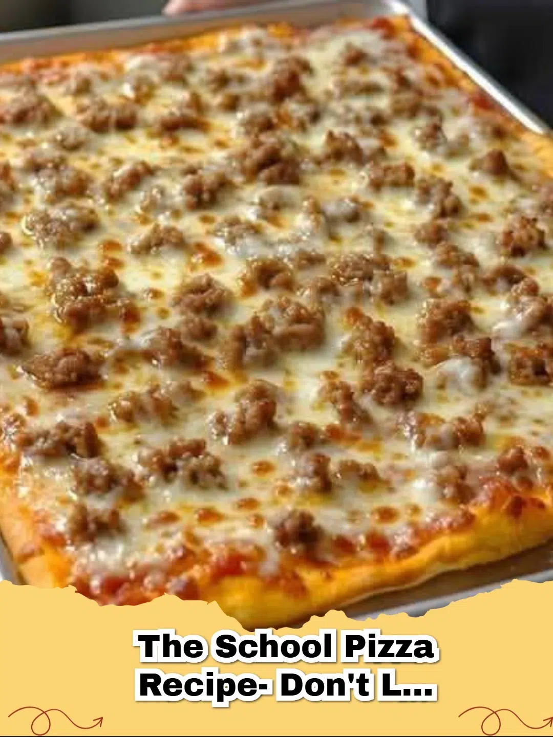 A golden brown Classic School Pizza, cut into squares on a sheet pan, with melted cheese and savory meat toppings.