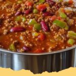 A close-up of a steaming bowl of homemade Wendy's Chili with shredded cheese and green onions.