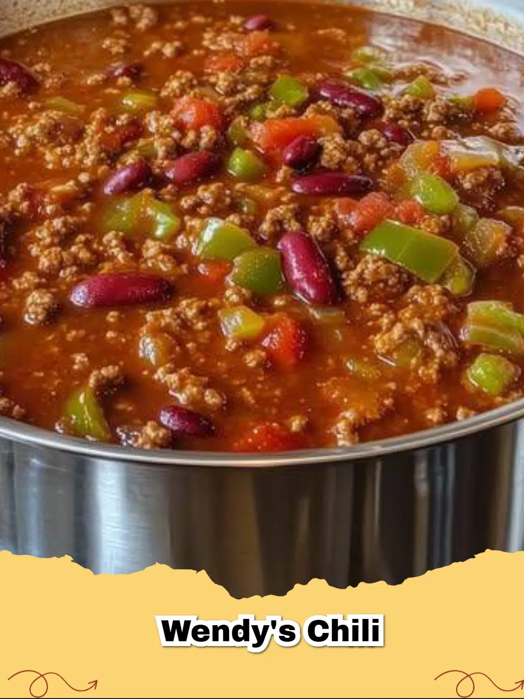 A close-up of a steaming bowl of homemade Wendy's Chili with shredded cheese and green onions.