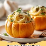 Creamy Pumpkin Alfredo Pasta served in mini roasted pumpkin cauldrons, garnished with fresh parsley and pepitas.