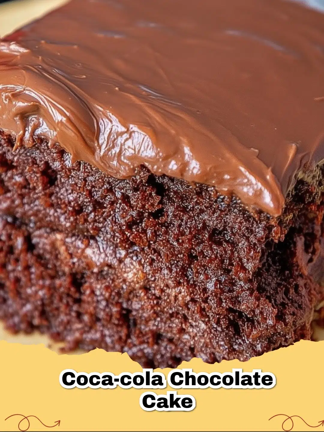 A slice of Decadent Coca-Cola Chocolate Cake with warm, glossy chocolate frosting and a drizzle of chocolate syrup.