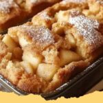 Two golden-brown loaves of Easy Cake Mix Apple Pie Bread, sliced, with fresh apples and cinnamon sticks in the background.