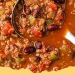 A steaming bowl of easy homemade chili topped with shredded cheddar cheese and a dollop of sour cream