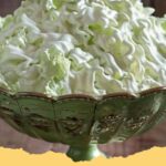 A bowl of vibrant green Easy Watergate Salad with mini marshmallows and chopped nuts