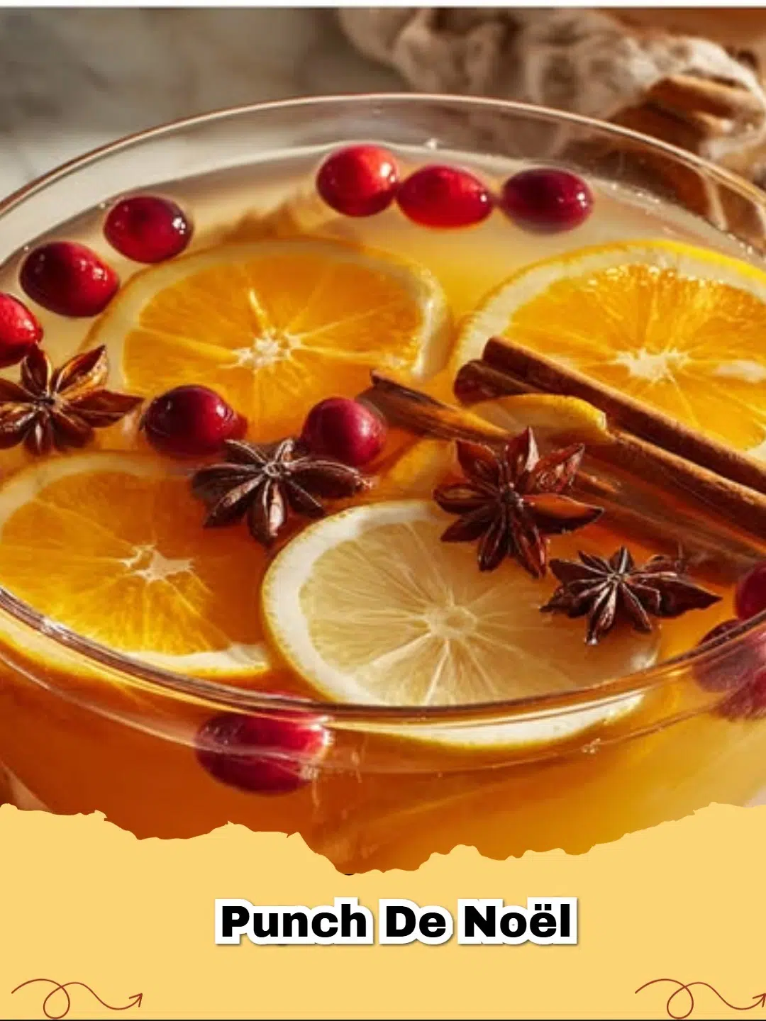 A steaming mug of Punch de Noël garnished with orange slices, cinnamon sticks, and star anise, on a festive wooden background.