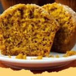 Close-up of a stack of fluffy homemade pumpkin muffins with a light sprinkle of sugar on top, perfect for a fall breakfast.