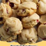 Close-up of frosted cranberry walnut drop cookies on a cooling rack, garnished with a few whole cranberries and walnuts.