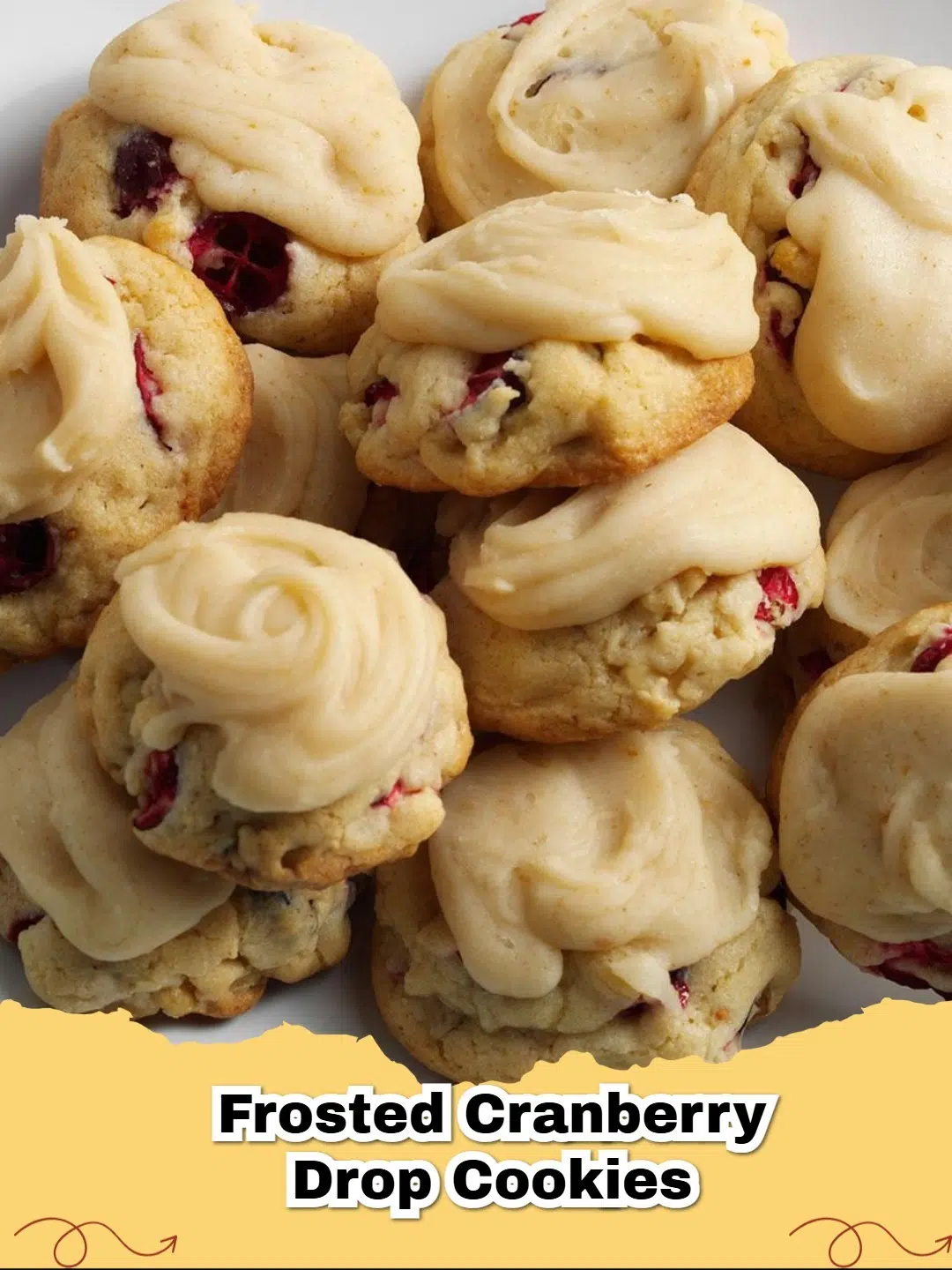 Close-up of frosted cranberry walnut drop cookies on a cooling rack, garnished with a few whole cranberries and walnuts.