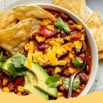 A cozy bowl of healthy and hearty turkey chili, garnished with fresh cilantro and shredded cheese, ready to be enjoyed.