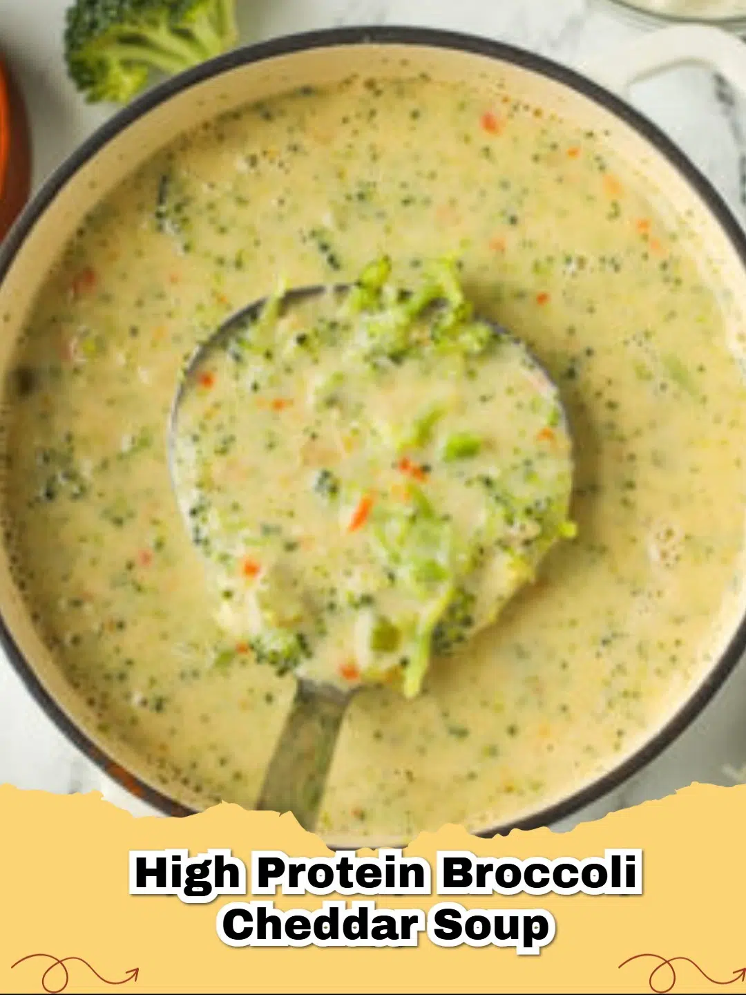 A steaming bowl of creamy High Protein Broccoli Cheddar Soup garnished with fresh parsley and shredded cheddar.