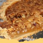 A slice of Kentucky Sawdust Pie with a flaky crust and rich, crumbly filling, garnished with whipped cream.