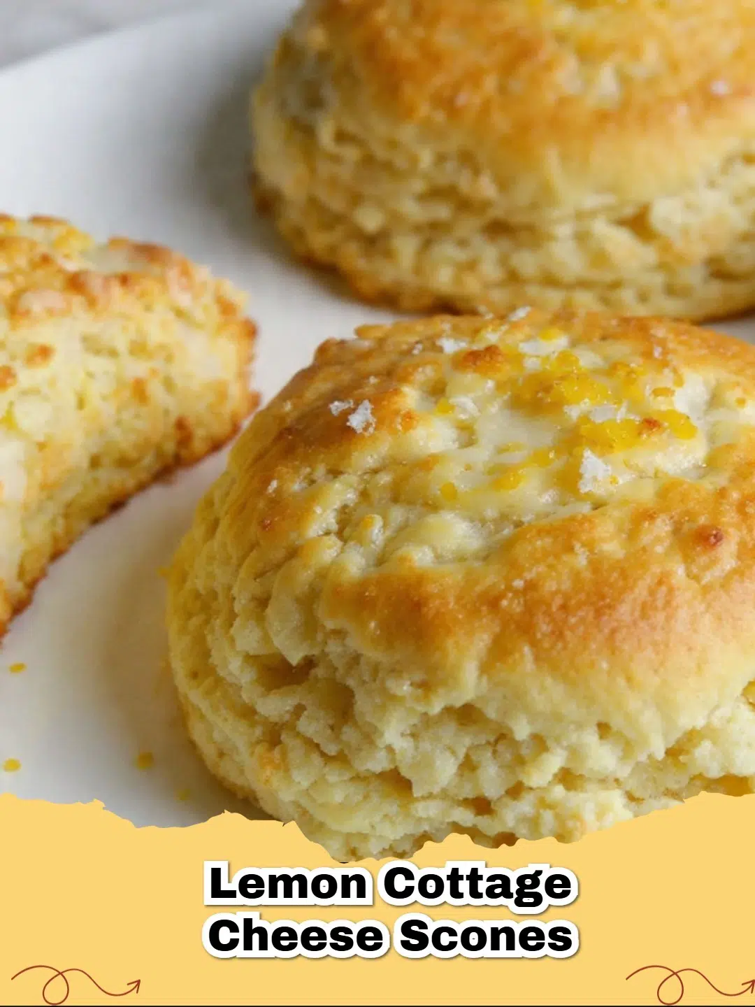 Close-up of golden-brown lemon cottage cheese scones drizzled with lemon glaze on a cooling rack.