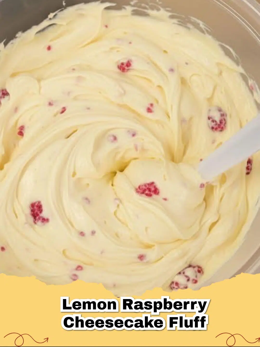 A close-up of light and airy No-Bake Sugar-Free Lemon Raspberry Cheesecake Fluff in a glass dish, garnished with fresh raspberries and a lemon slice.
