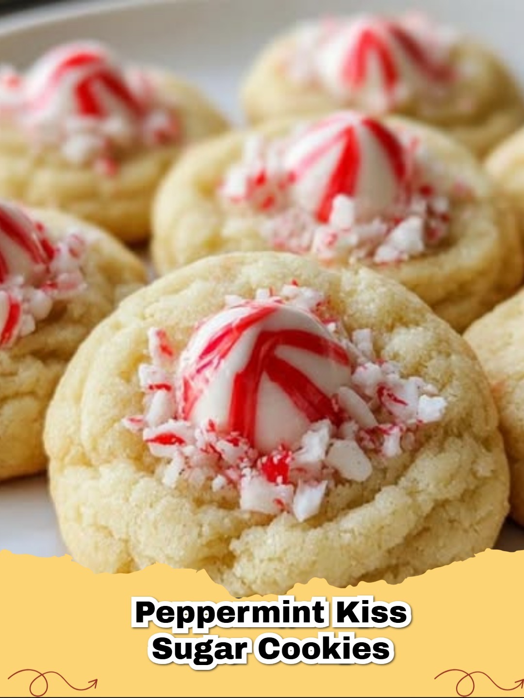 A plate of festive Peppermint Hershey Kiss Sugar Cookies with red and white peppermint swirls.