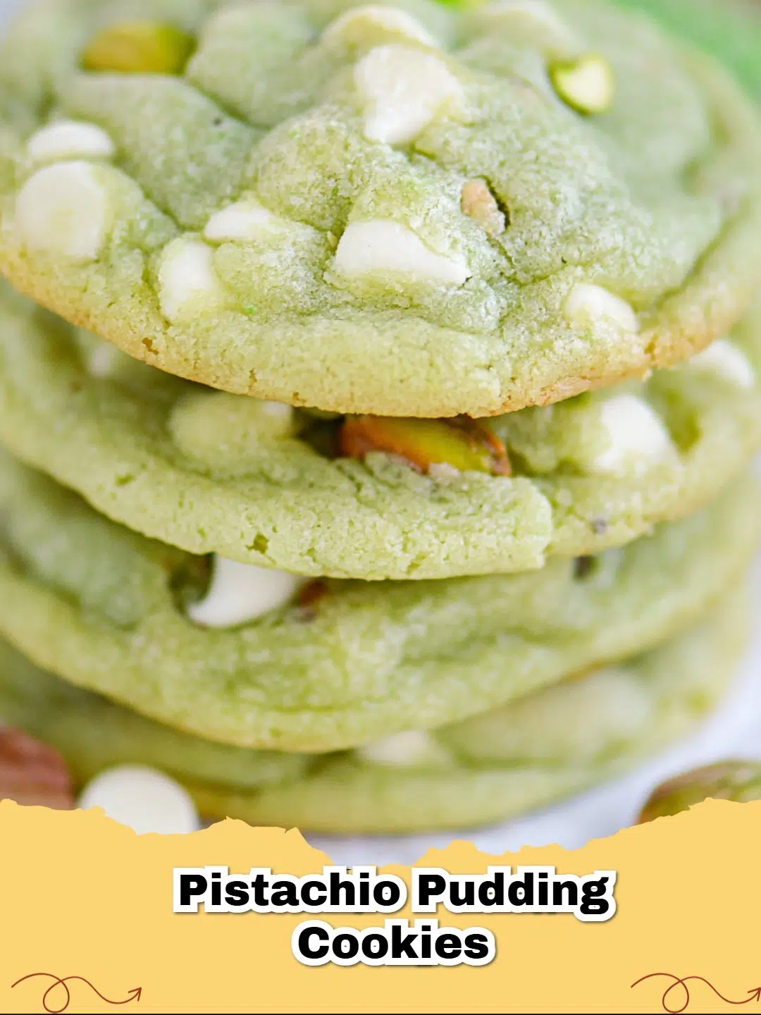 Close-up of vibrant green pistachio pudding cookies stacked on a cooling rack with a few loose pistachios