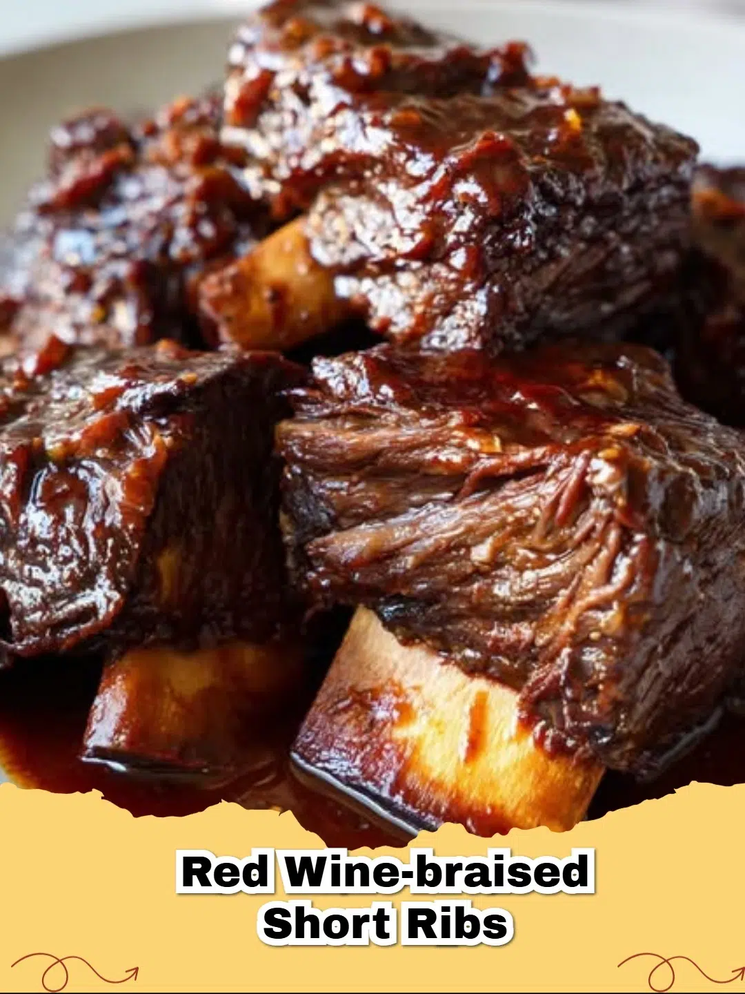Platter of tender red wine-braised short ribs with a rich, dark sauce, garnished with fresh herbs, served on a rustic wooden board.