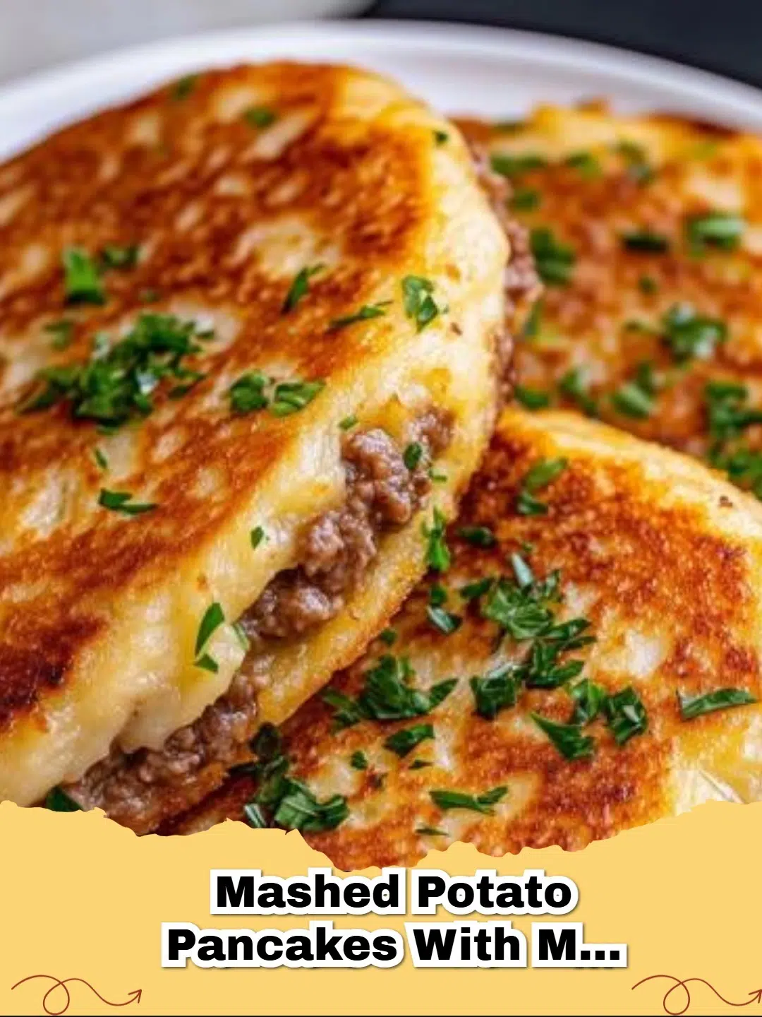 Savory meat-stuffed mashed potato pancakes, golden brown and crispy, served with a dollop of sour cream.