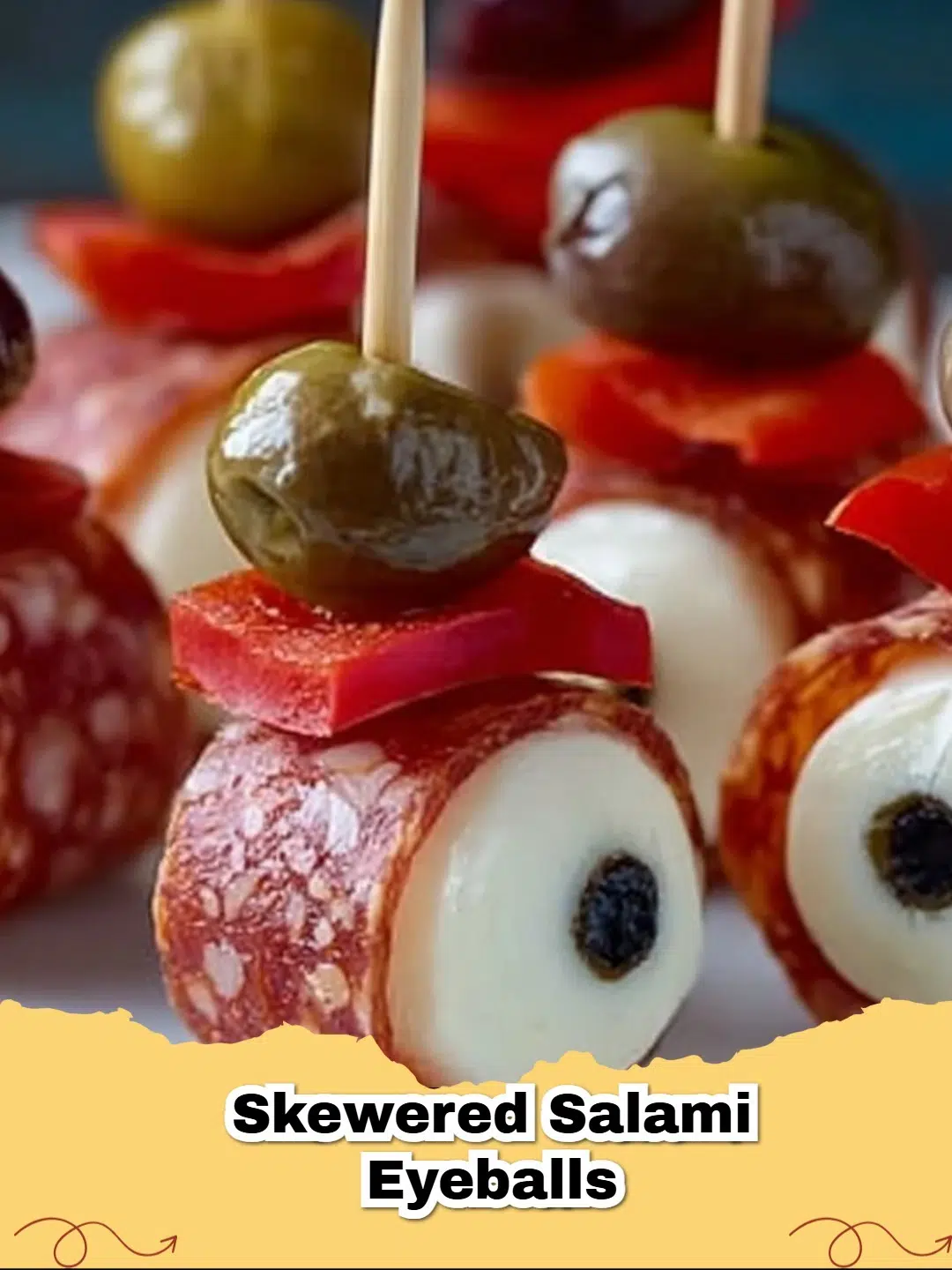 Spooky Skewered Pepperoni Eyeballs for a Halloween party, featuring mozzarella, pepperoni, olives, and red bell pepper veins.