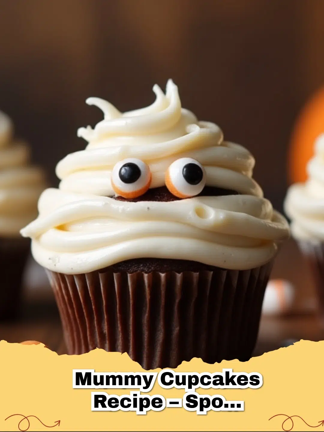 Adorable spooky Halloween mummy cupcakes with candy eyeballs on a cooling rack.