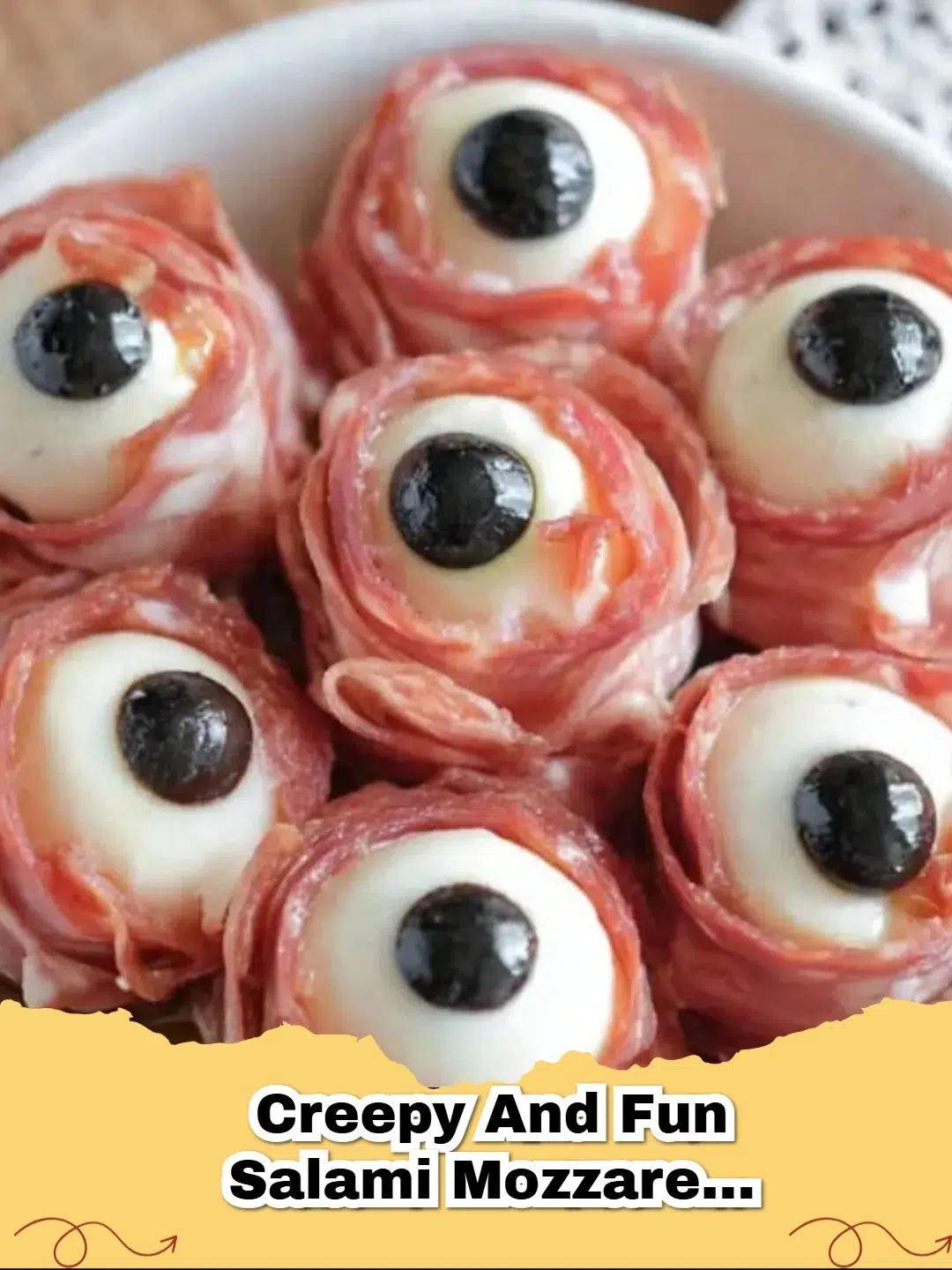 A close-up of spooky salami mozzarella olive eyeballs on skewers, ready for a Halloween party.