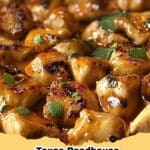 Close-up of a rustic cast iron skillet filled with creamy Texas Roadhouse Butter Chicken Skillet, garnished with fresh cilantro, ready to serve.